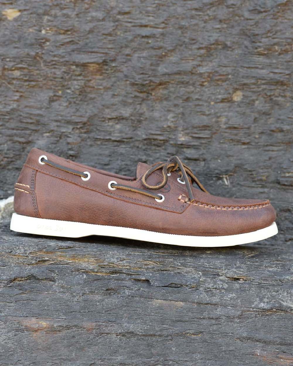 Russet Coloured Orca Bay Mens Maine Deck Shoes on stone background 