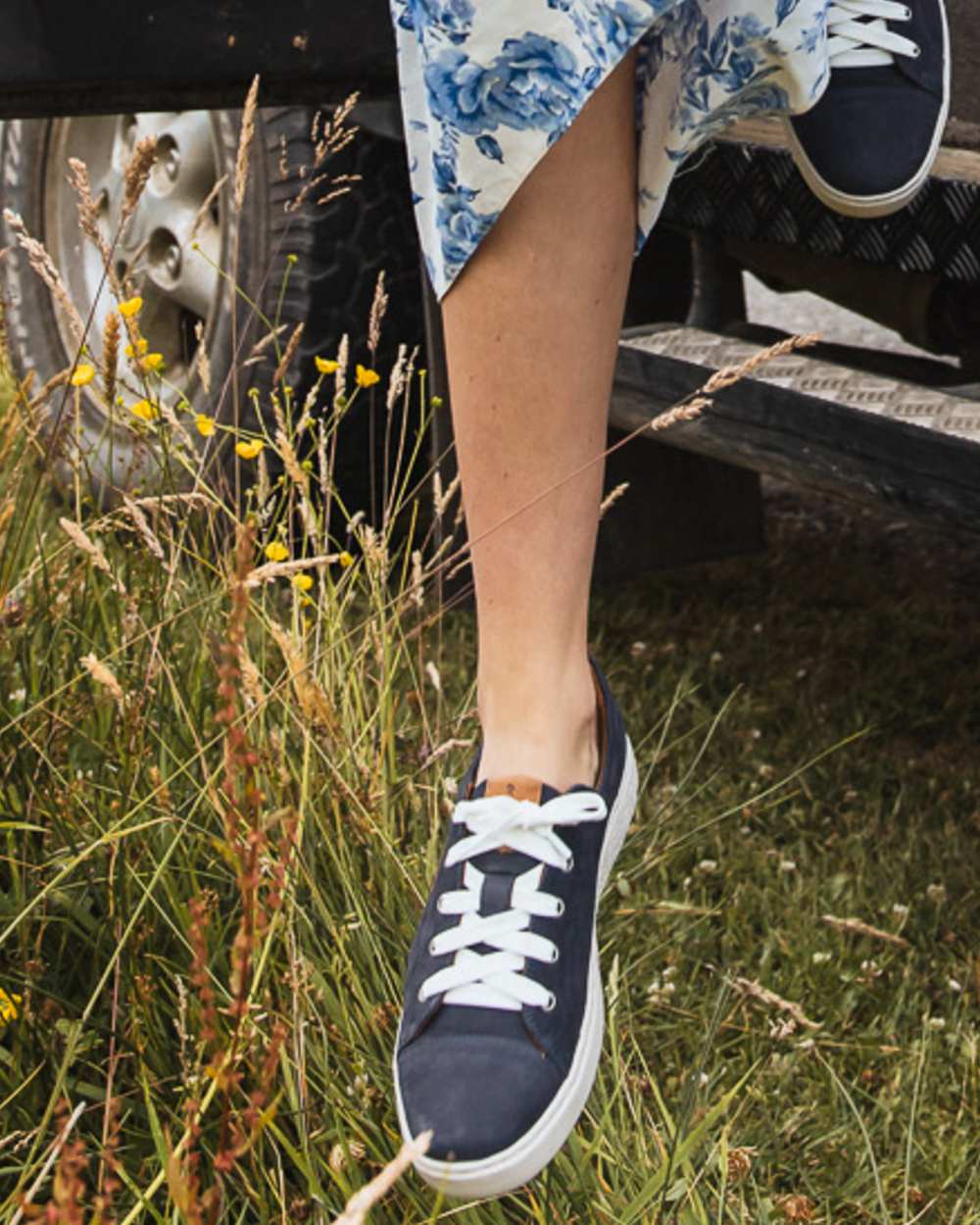 Indigo coloured Orca Bay Womens Mayfair Trainers on grassy background 