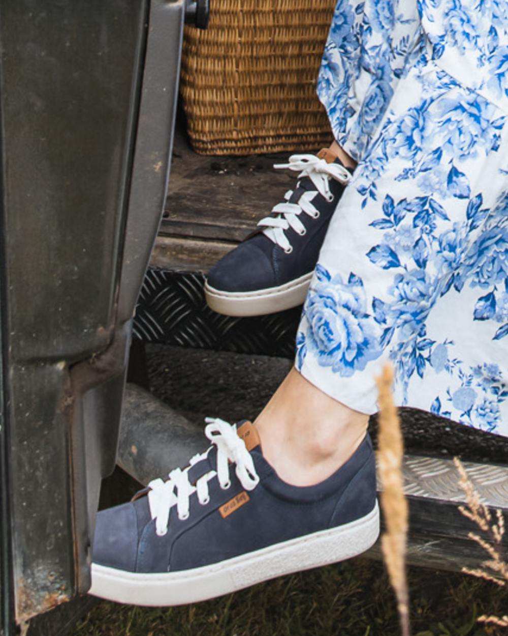 Indigo coloured Orca Bay Womens Mayfair Trainers on grassy background 