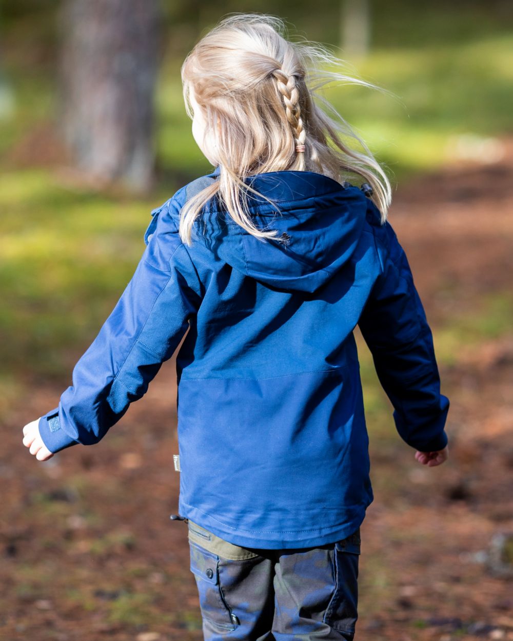 Dark Dive coloured Pinewood Childrens Finnveden Hybrid Jacket on forest background 