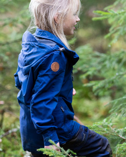 Dark Dive coloured Pinewood Childrens Finnveden Hybrid Jacket on forest background 