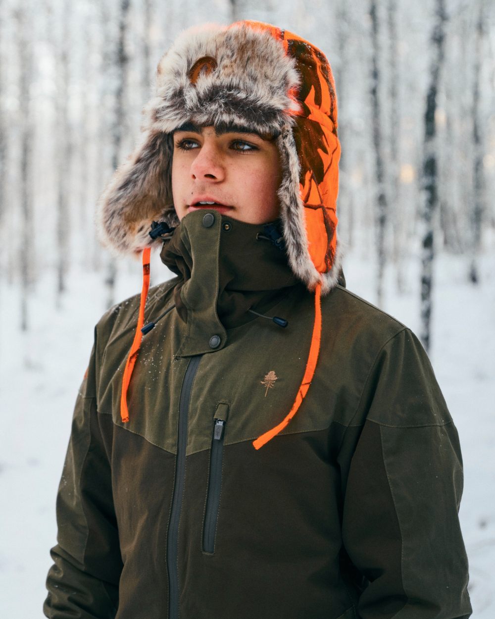 Hunting Olive coloured Pinewood Childrens Finnveden Hybrid Jacket on snow background 