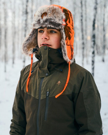 Hunting Olive coloured Pinewood Childrens Finnveden Hybrid Jacket on snow background 