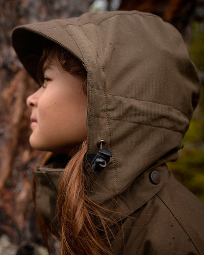 Hunting Olive coloured Pinewood Childrens Finnveden Hybrid Jacket on forest background 