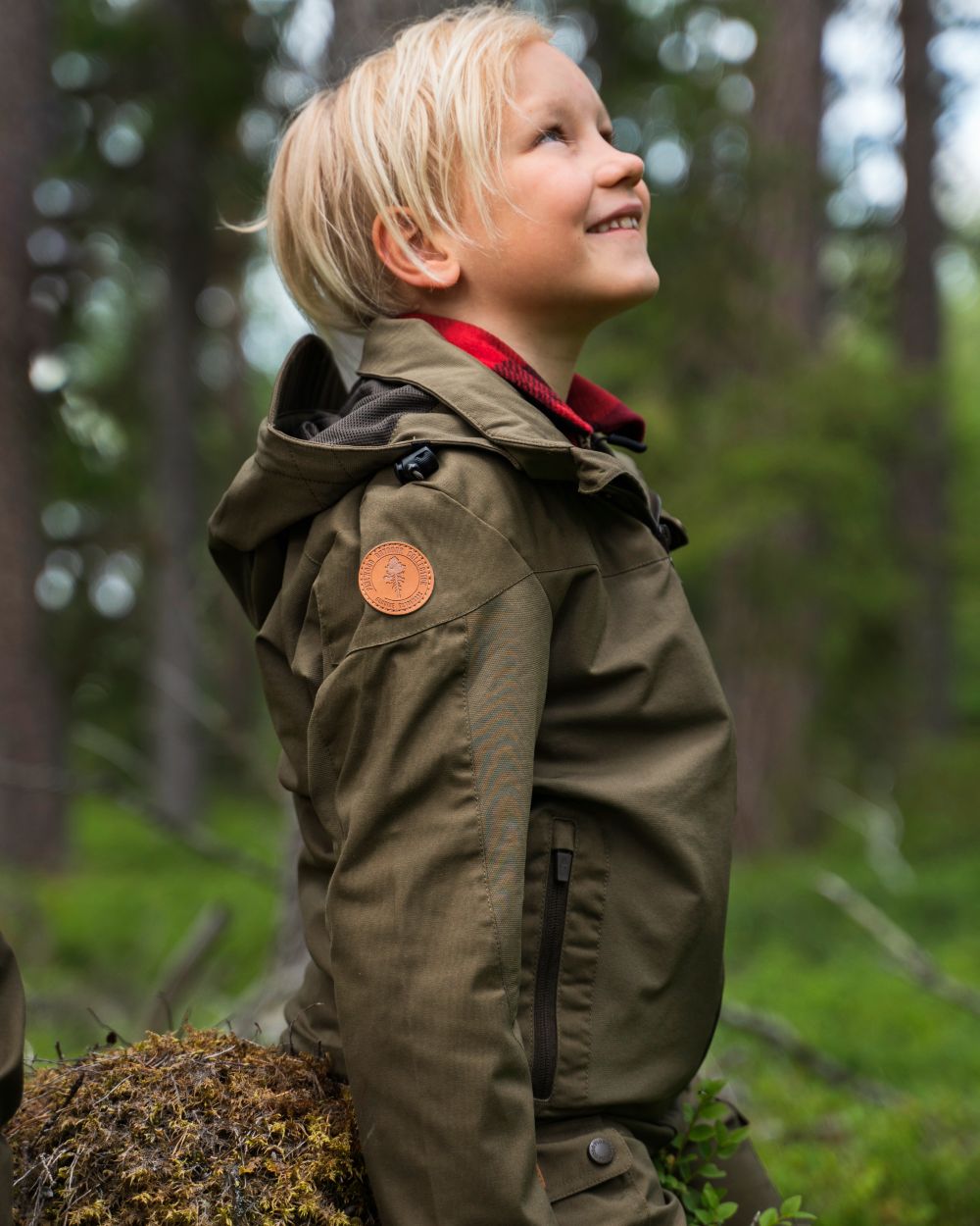 Hunting Olive coloured Pinewood Childrens Finnveden Hybrid Jacket on forest background 