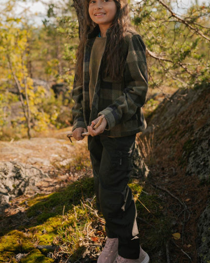 Black coloured Pinewood Childrens Lappland Trousers on forest background 