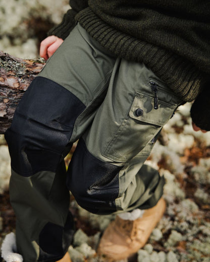 Mid Green Black coloured Pinewood Childrens Lappland Trousers on forest background 
