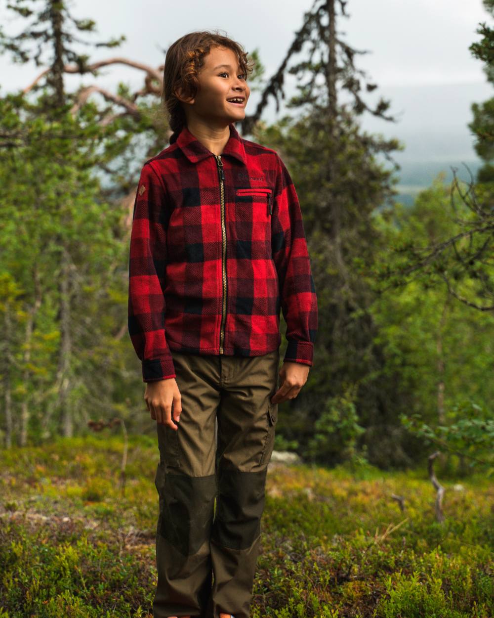 Olive Moss Green coloured Pinewood Childrens Lappland Trousers on forest background 