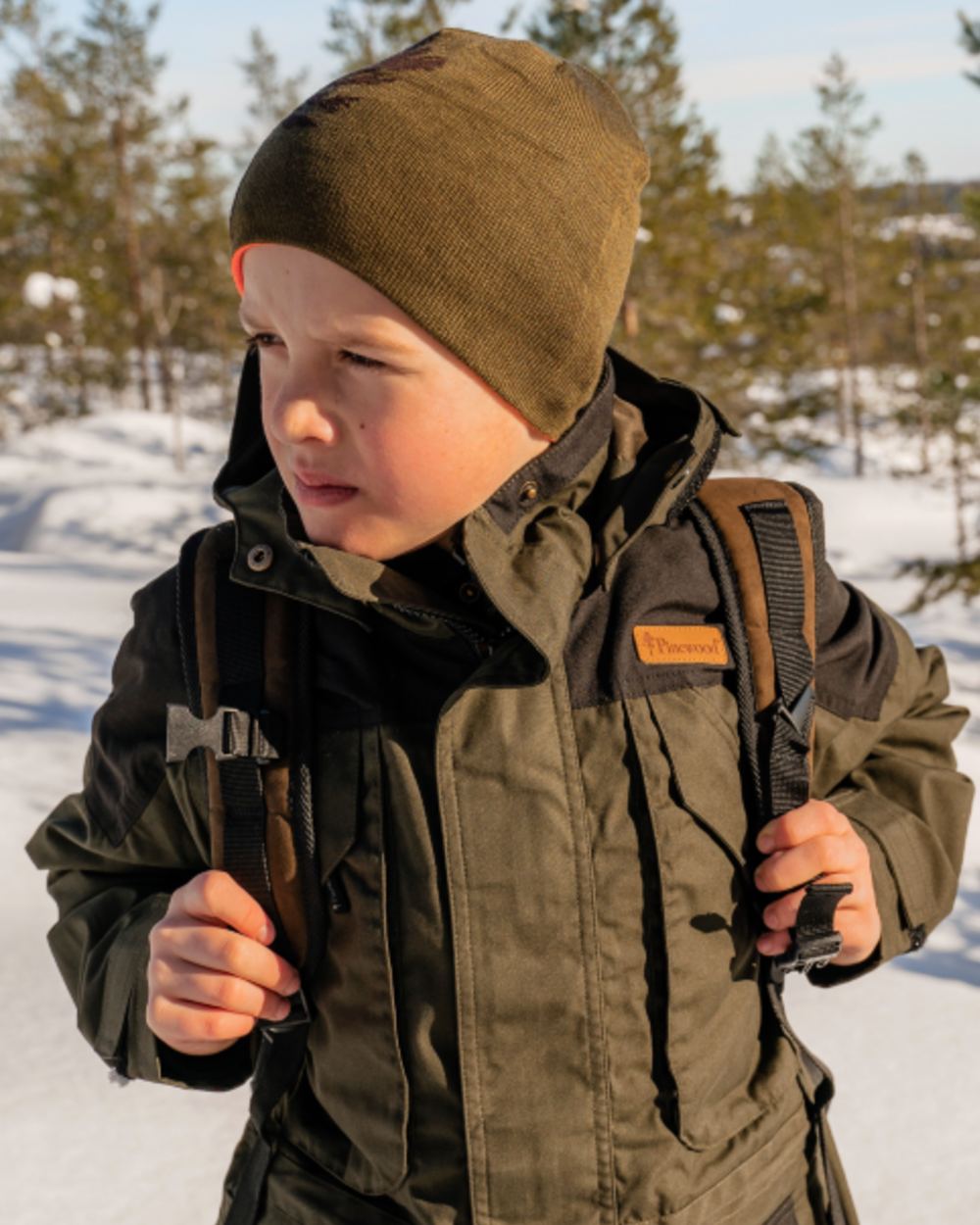Orange Green coloured Pinewood Childrens Tree Hat on snow background 