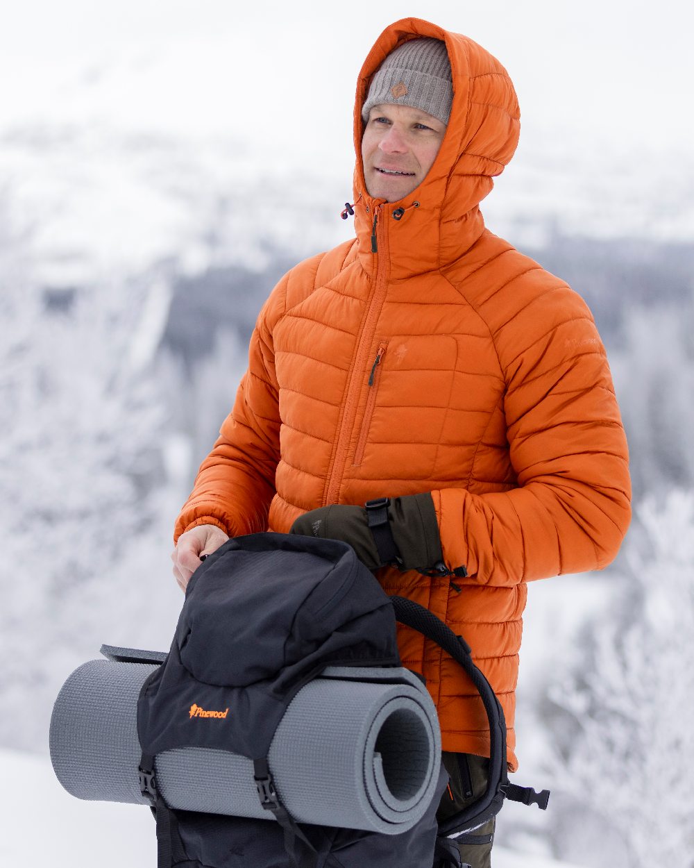 Burned Orange Coloured Pinewood Mens Abisko Insulation Jacket on snow background 