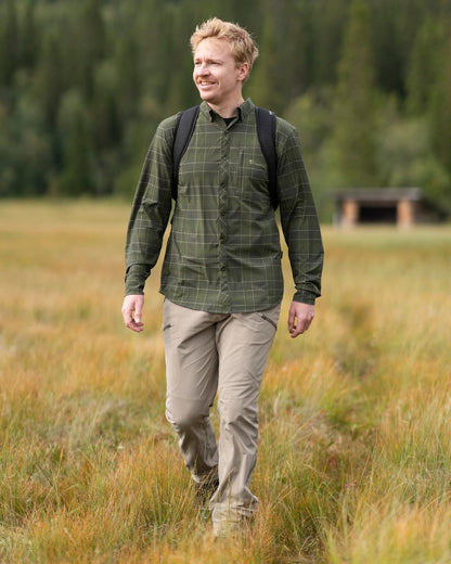 Moss Green Coloured Pinewood Mens Abisko Trekking Long Sleeve Shirt on outdoor background 