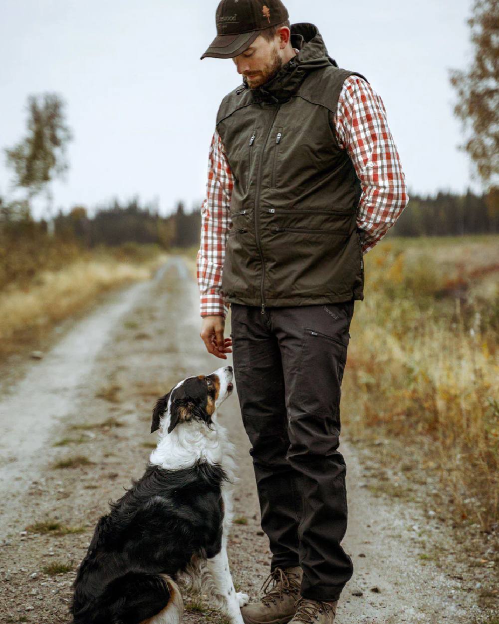 Moss Green coloured Pinewood Mens Dog Sports Windblocker Vest on grassy background 