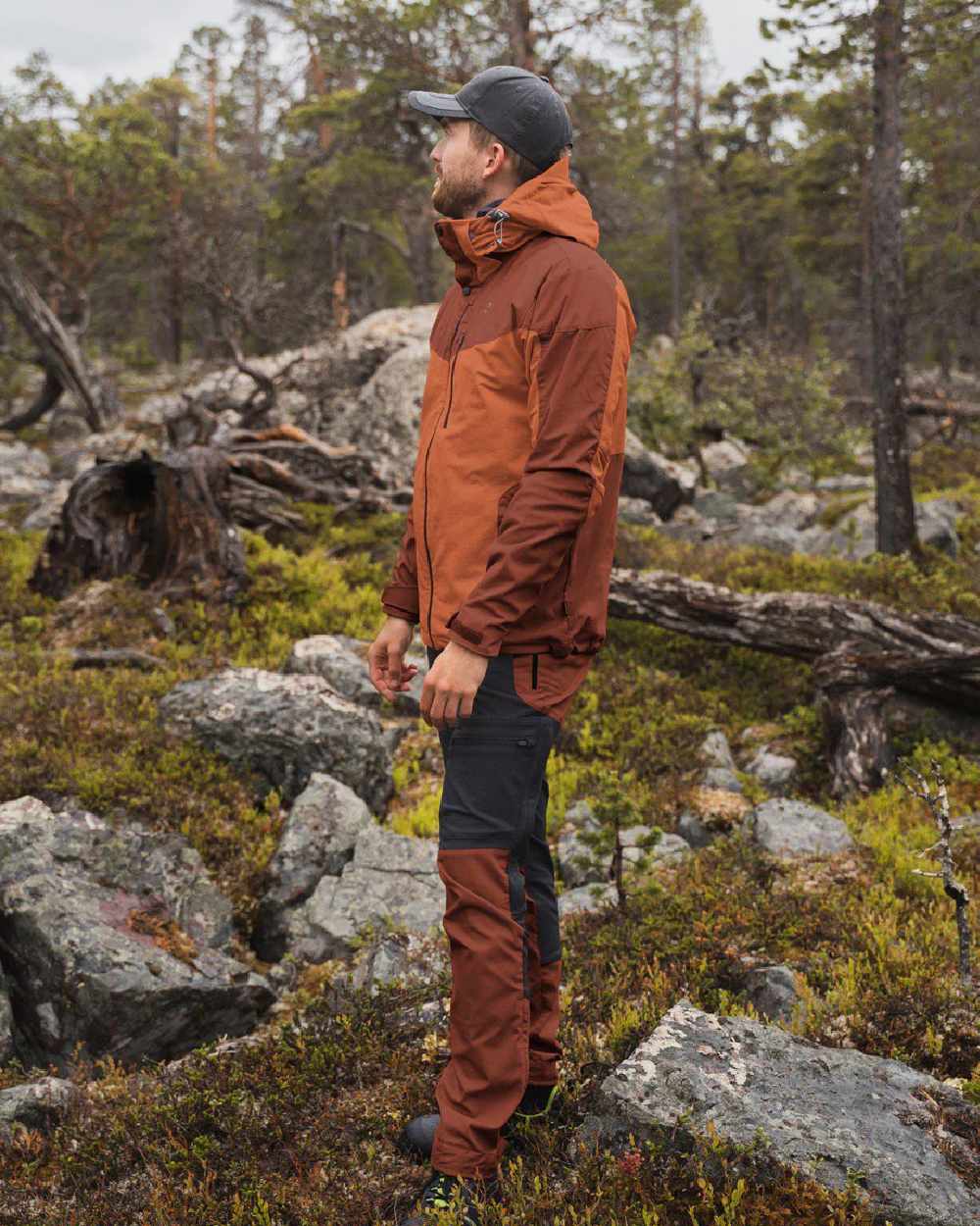 Terracotta coloured Pinewood Mens Finnveden Hybrid Jacket on forest background 