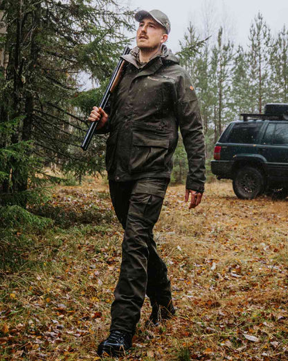Dark Moss Green coloured Pinewood Mens Furudal Expert 2L Hunting Jacket on forest background 