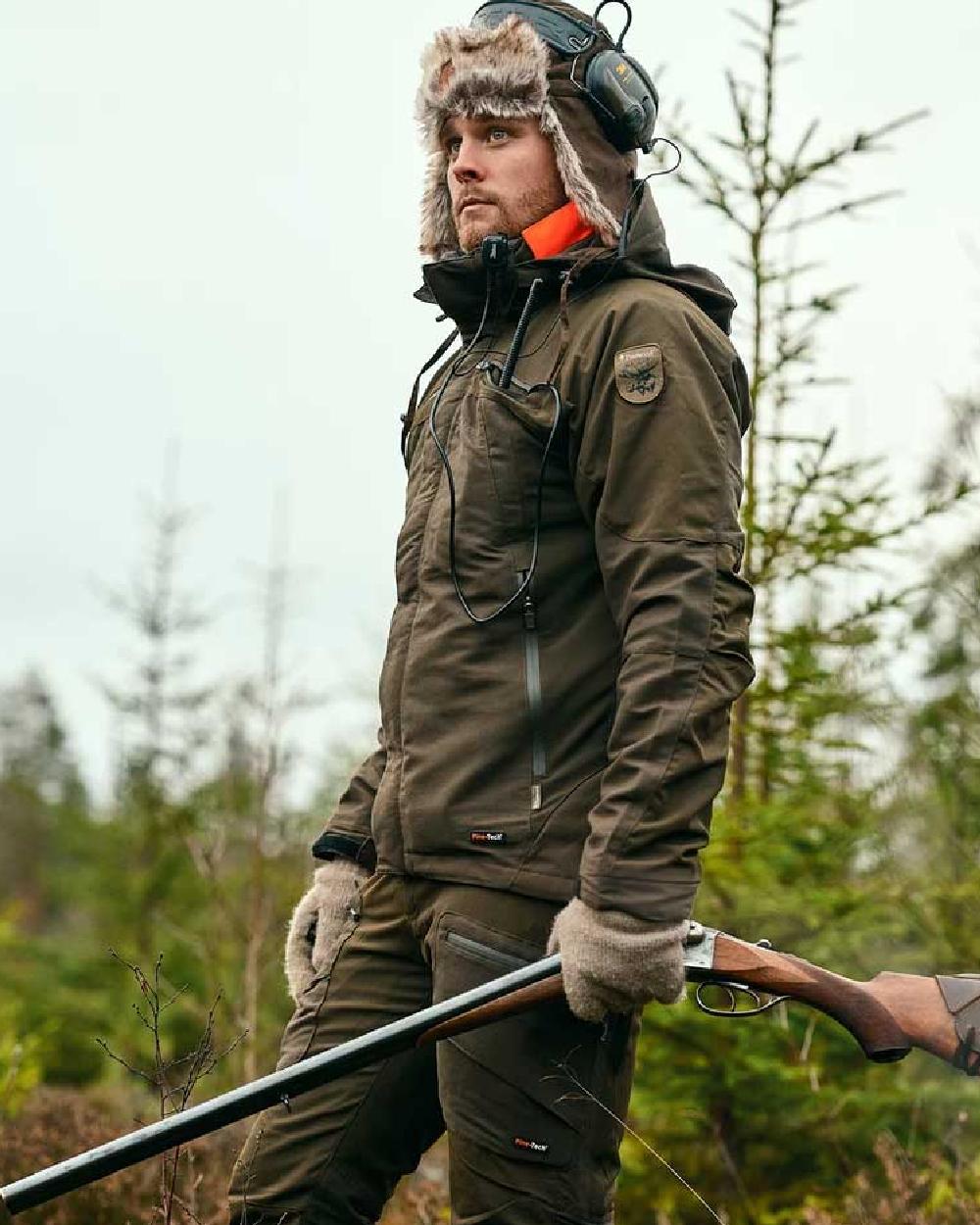 Moss Green coloured Pinewood Mens Hunter Pro Xtreme 2.0 Jacket on forest background 