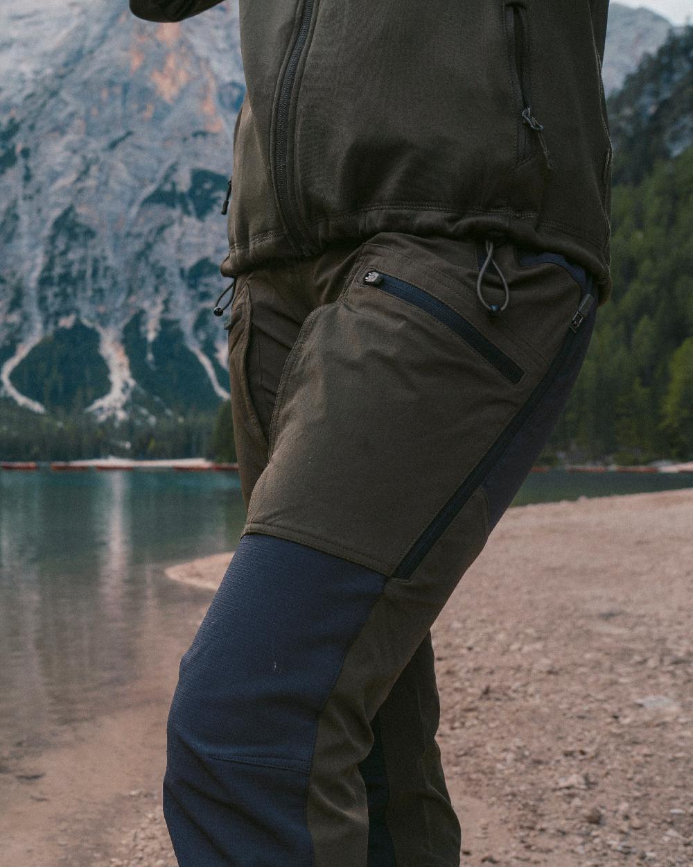 Moss Green Coloured Pinewood Womens Abisko Adventure Trousers on mountain background 