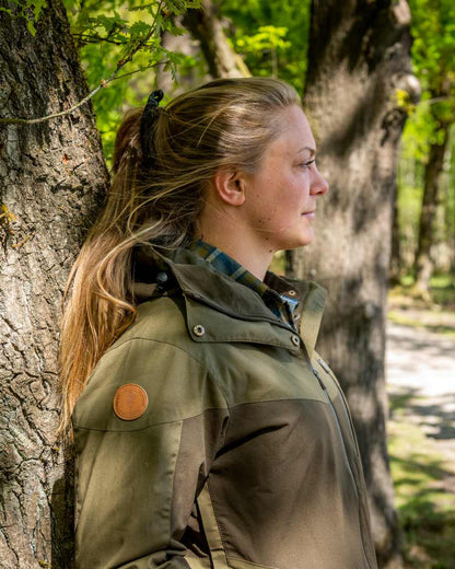 Dark Olive Hunting Olive Coloured Pinewood Womens Finnveden Hybrid Extreme Jacket on outdoor background 