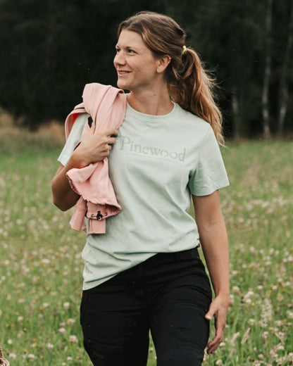 Frosty Green coloured Pinewood Womens Outdoor Life T-Shirt on forest background 