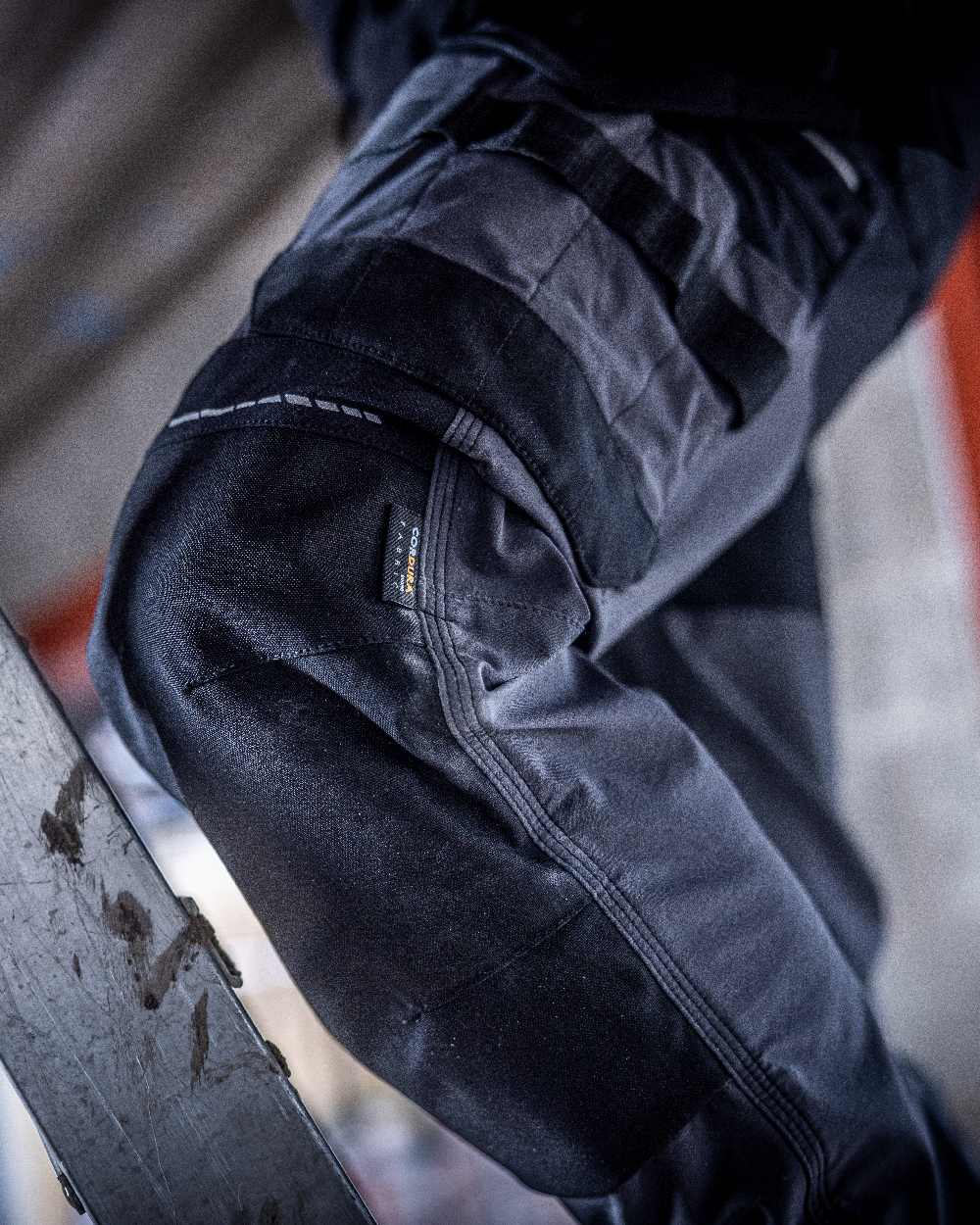 Slate Grey Black coloured Regatta Mens 4Tex Stretch Holster Trousers on wall background 