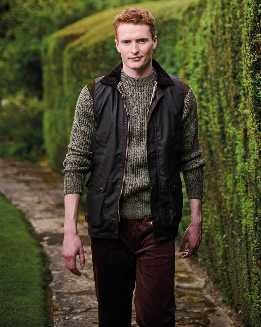 Brown coloured Regatta Mens Banbury Wax Bodywarmer on blurry green background 