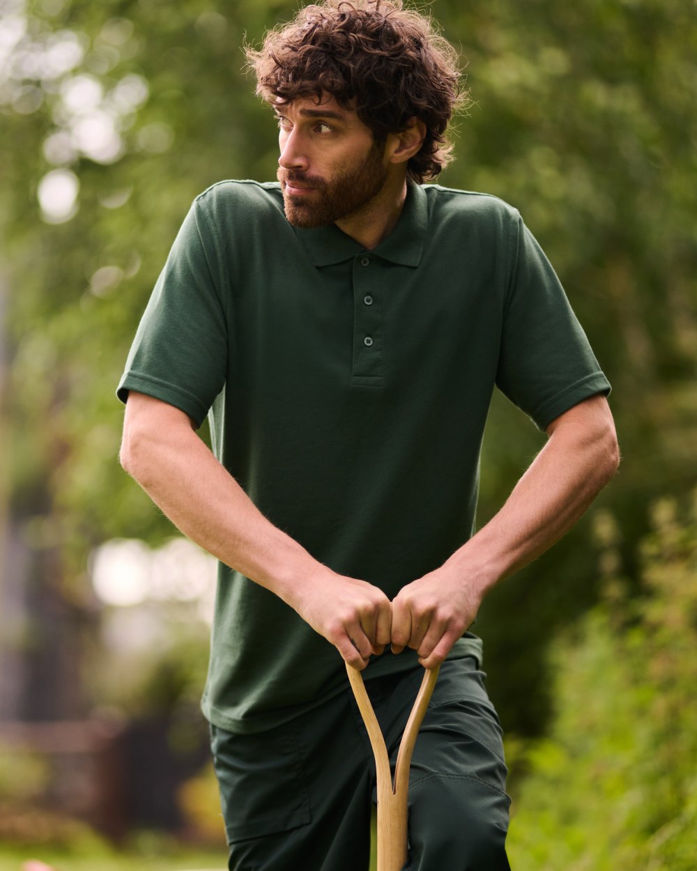 Dark Green coloured Regatta Professional Mens 65/35 Short Sleeves Polo Top on outdoor background 