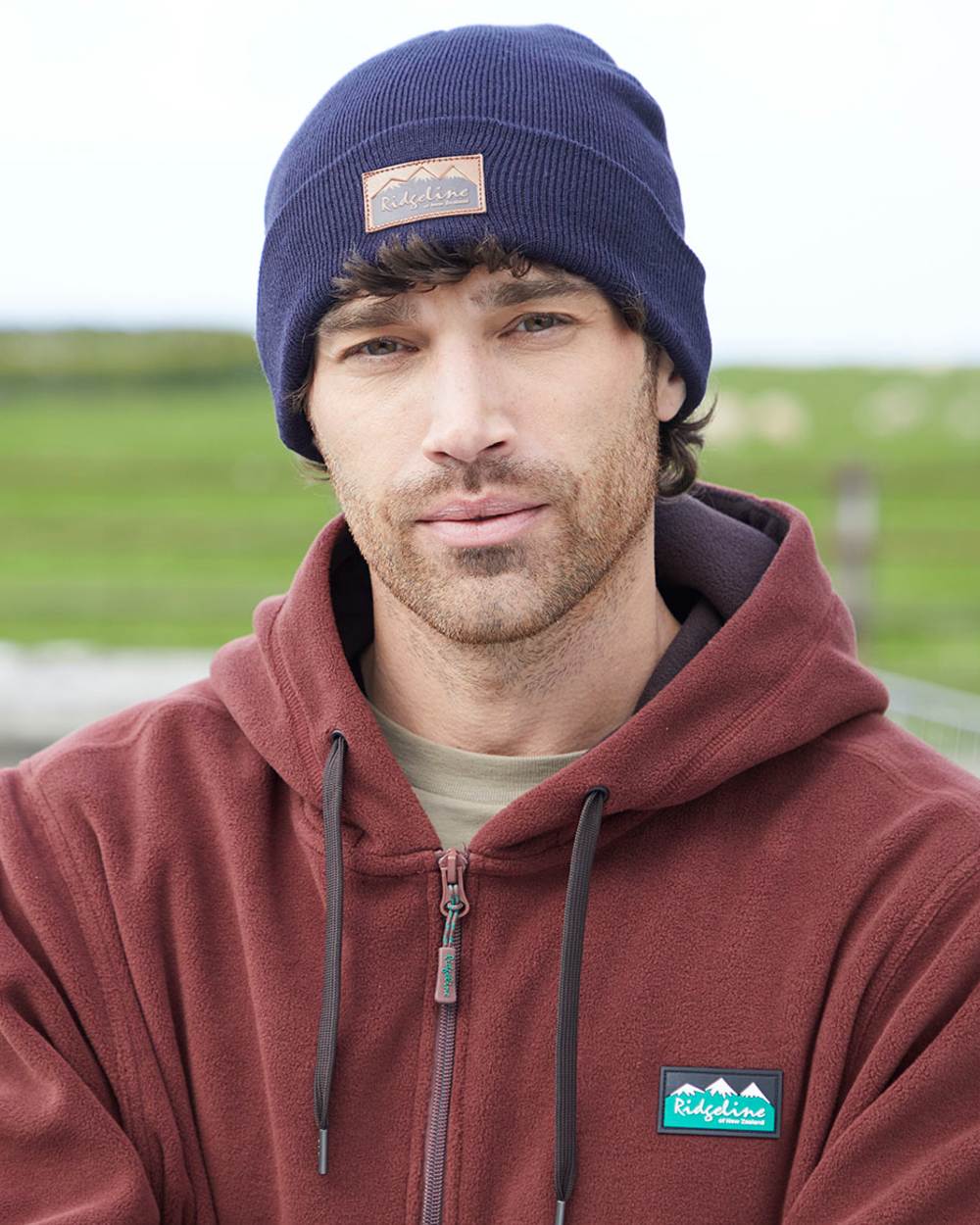 Navy coloured Ridgeline Heritage Fine Knit Beanie on grassy background 