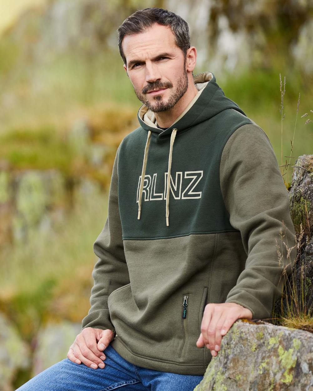 Olive coloured Ridgeline Mens South Island Hoodie on forest background 