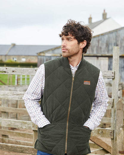 Deep Forest coloured Ridgeline Mens Wester Skeld Gilet on farm background 