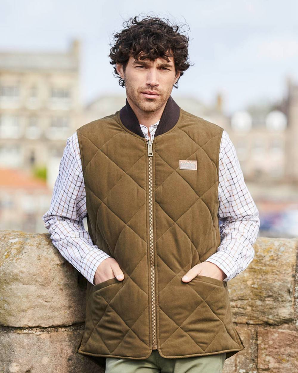 Moody Teak coloured Ridgeline Mens Wester Skeld Gilet on farm background 