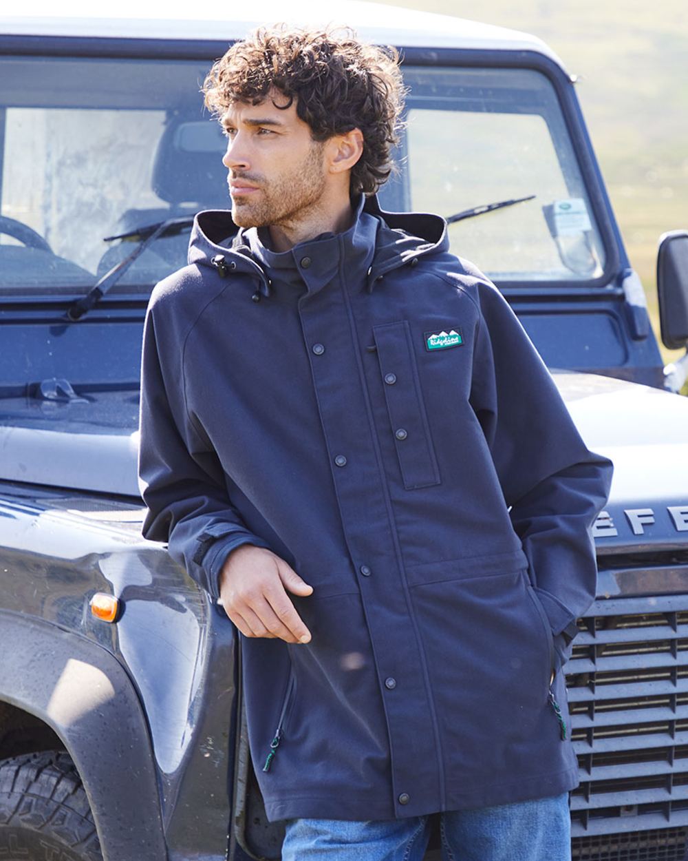 Navy coloured Ridgeline Monsoon Classic Waterproof Jacket on jeep background 