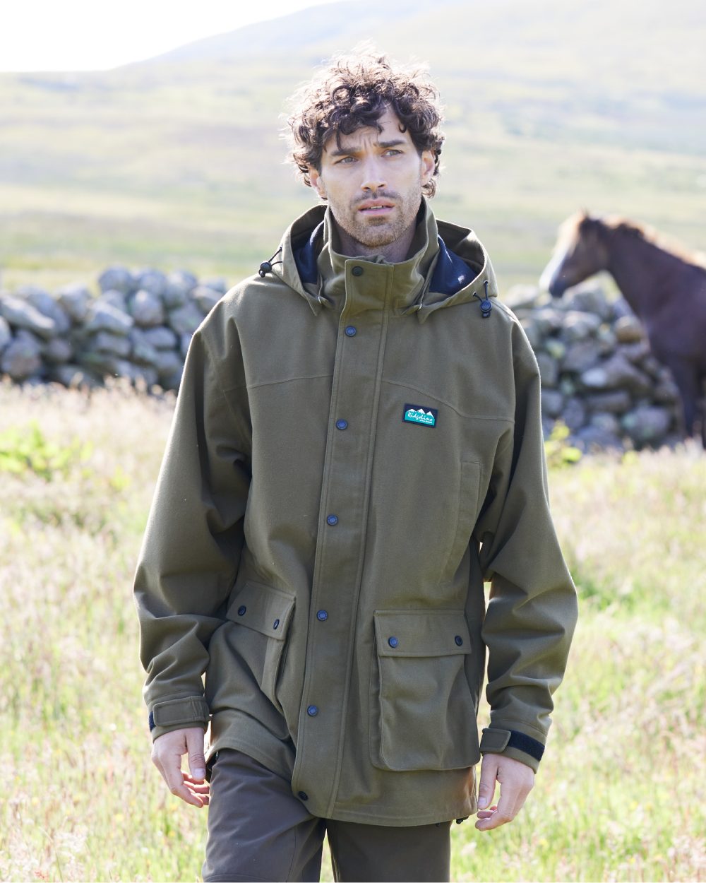 Teak coloured Ridgeline Torrent Waterproof Jacket on hilly background 