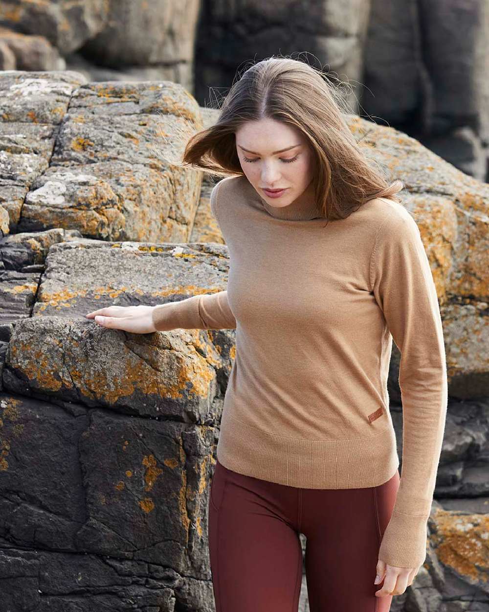 Sienna coloured Ridgeline Womens Melford Knit Roll Neck Jumper on rocky background 