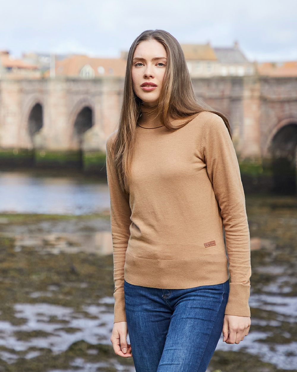 Sienna coloured Ridgeline Womens Melford Knit Roll Neck Jumper on field background 
