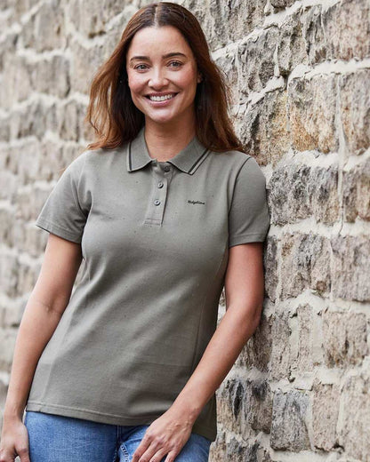 Smokey Olive coloured Ridgeline Womens Kilworth Polo Shirt on stone wall background 