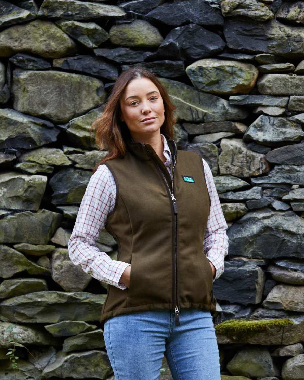 Teak coloured Ridgeline Womens Monarch Gilet on rock wall background 