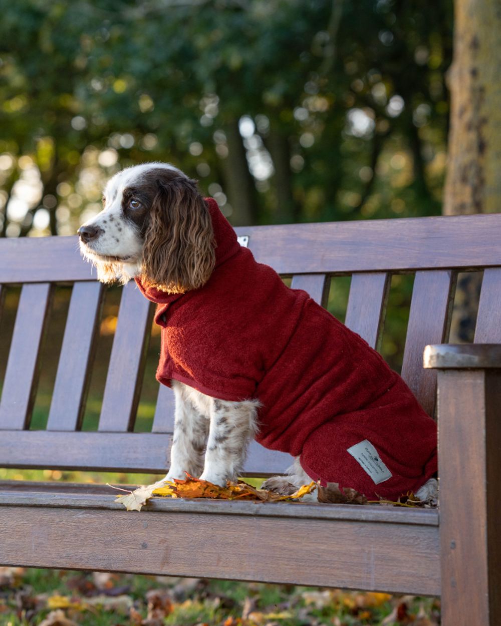 Rosehip coloured Ruff &amp; Tumble Classic Dog Drying Coat side on a bench 
