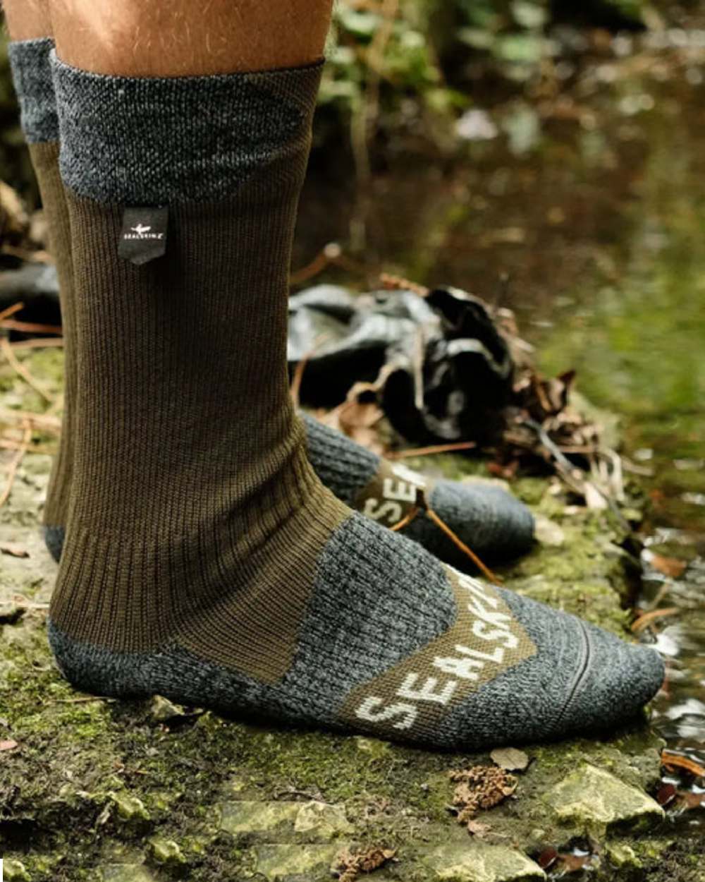 Olive Coloured Sealskinz Raynham Waterproof All Weather Mid Length Sock on outdoor background 