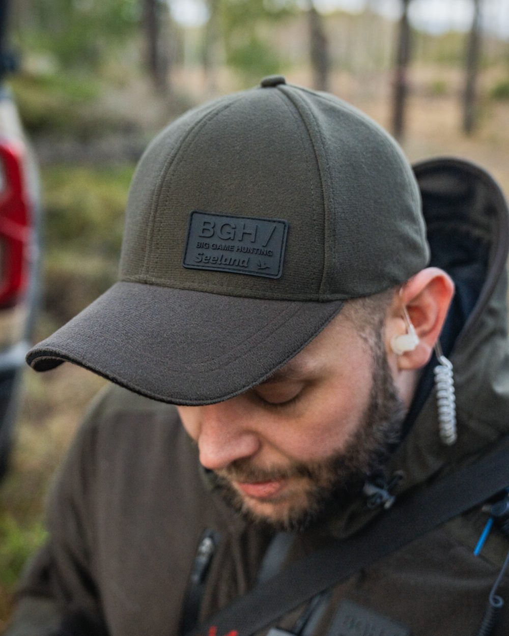 Pine Green coloured Seeland Chaser BGH Cap on forest background 