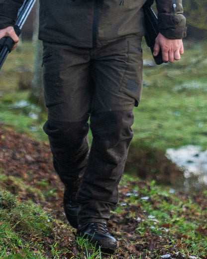 Pine Green Coloured Seeland Chaser Trousers on forest background 