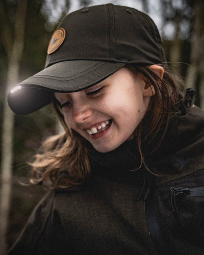 Pine Green coloured Seeland Childrens Skarn LED Junior Cap on forest background 