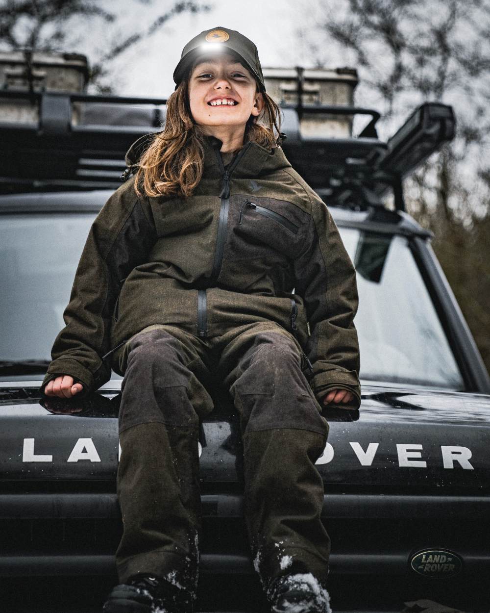 Pine Green coloured Seeland Childrens Skarn LED Junior Cap on forest background 