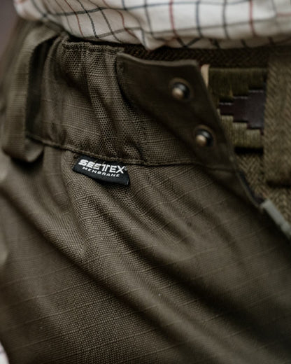 Shaded Olive coloured Seeland Mens Buckthorn Duro Overtrousers on forest background 