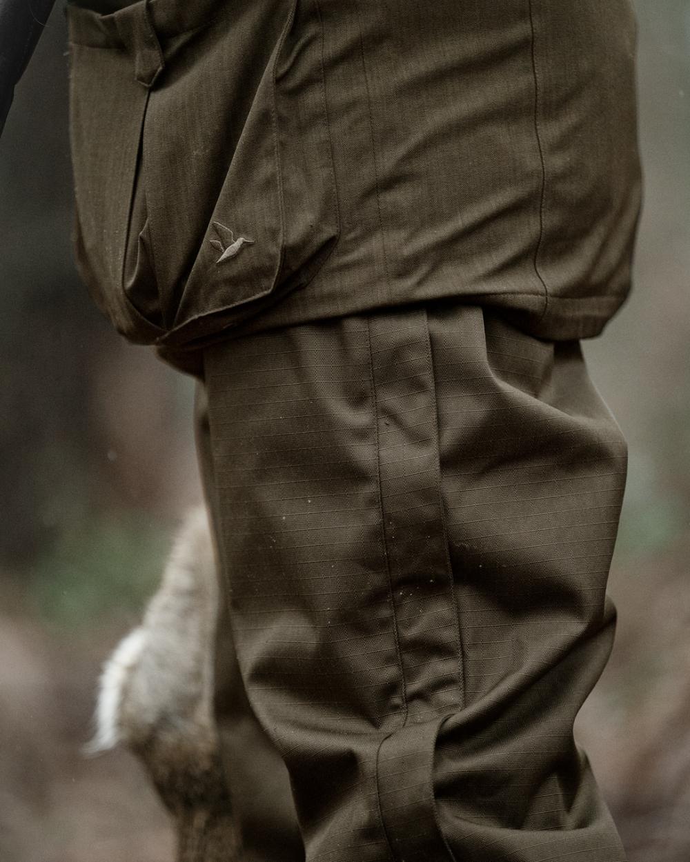 Shaded Olive coloured Seeland Mens Buckthorn Duro Overtrousers on forest background 
