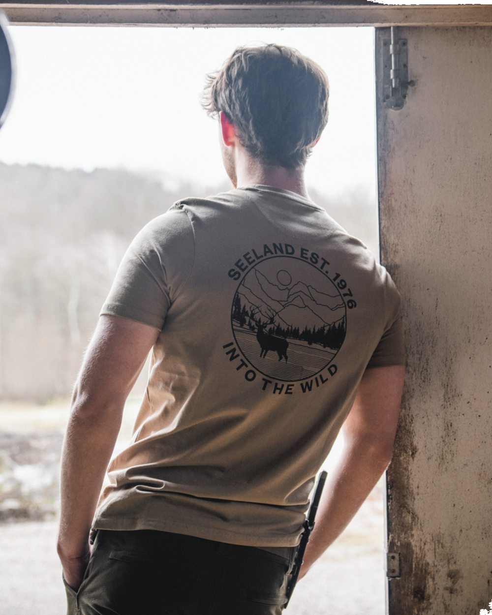 Covert Green coloured Seeland Mens Hunting Landscape T-Shirt on factory background 
