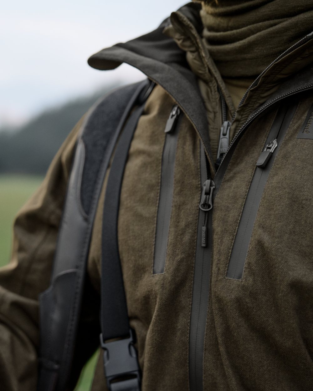 Pine Green Melange coloured Seeland Mens Quest Jacket on forest background 