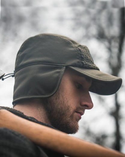 Pine Green coloured Seeland Mens Teddy Fold Down Cap on forest background 