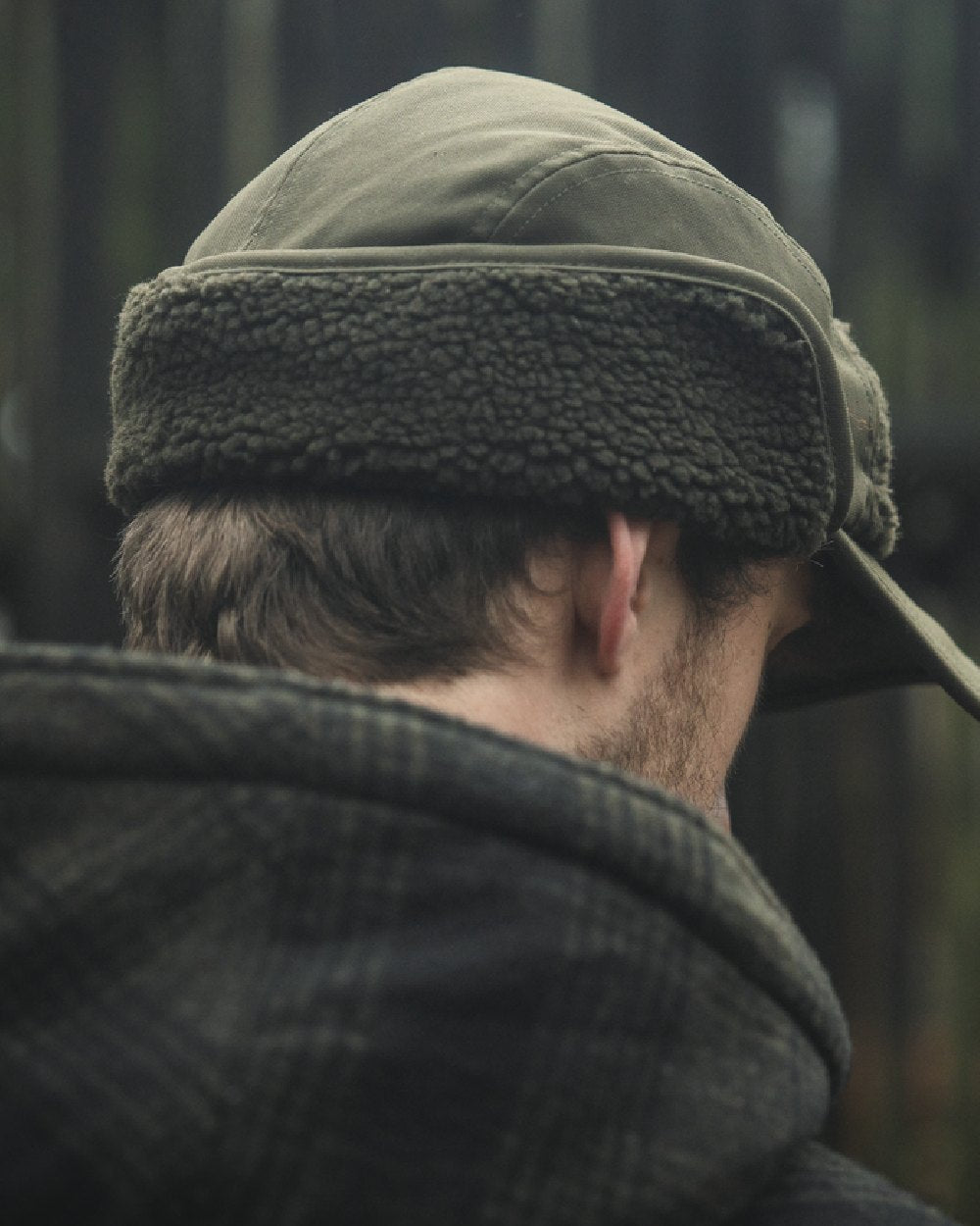 Pine Green coloured Seeland Mens Teddy Fold Down Cap on forest background 