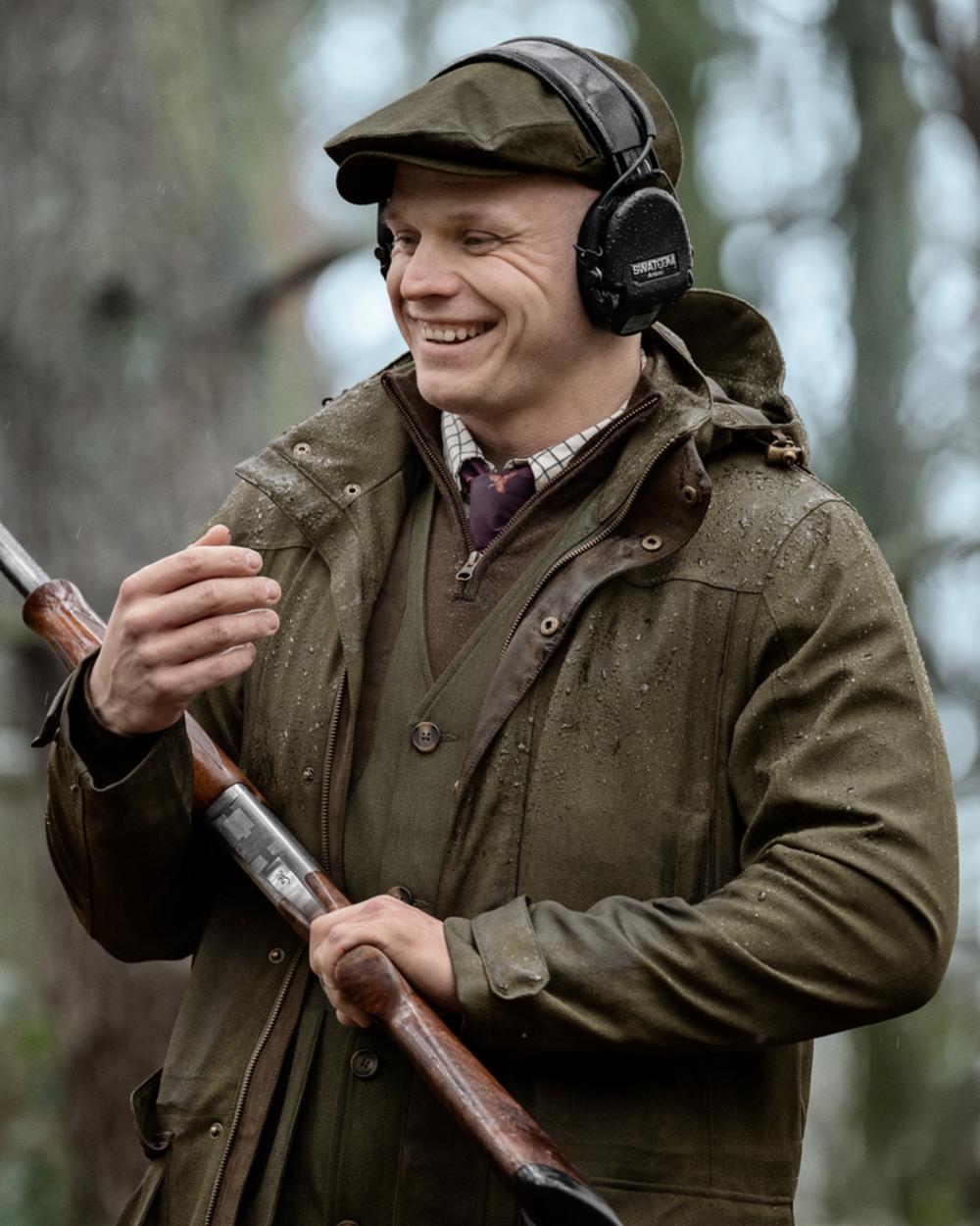 Shaded Olive coloured Seeland Mens Woodcock Royale Jacket on forest background 