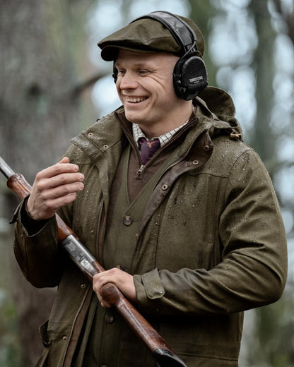 Shaded Olive coloured Seeland Mens Woodcock Royale Jacket on forest background 