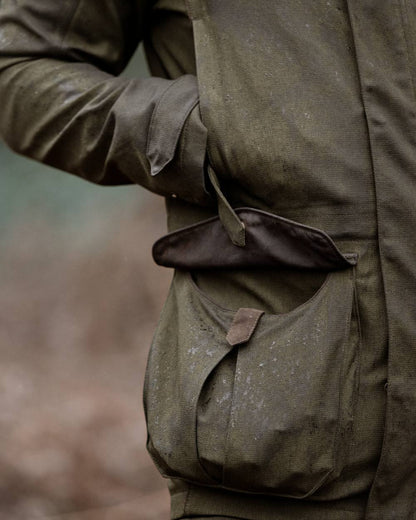 Shaded Olive coloured Seeland Mens Woodcock Royale Jacket on forest background 